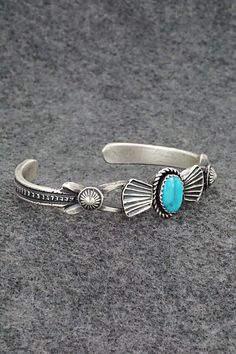 This turquoise and sterling silver bracelet was made by Navajo silversmiths Eva & Linberg Billah. The back is signed EL Billah and stamped sterling.Size: 5" (will fit up to a 6" wrist)Gap: 1"Width: 1/2"Cuff Width: 1/4"Free shipping on all orders! We ship with USPS and always include tracking. All orders ship within a day of payment.Returns are accepted up to 30 days after you receive your order. Just send us a message. Our shop offers cash back or store credit. The item must be returned in new c Southwestern Oxidized Adjustable Jewelry, Bohemian Stamped Blue Bracelets, Blue Stamped Bohemian Bracelets, Bohemian Blue Stamped Bracelets, Bohemian Engraved Turquoise Sterling Silver Bracelet, Southwestern Style Stamped Blue Bracelets, Western Style Blue Sterling Silver Bracelet Gift, Bohemian Turquoise Engraved Sterling Silver Bracelet, Southwestern Sterling Silver Cuff Bracelet In Blue