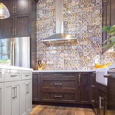 a kitchen with wooden cabinets and white counter tops, an oven hood over the stove