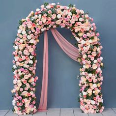 a floral arch decorated with pink and white flowers