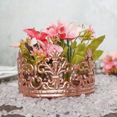 a pink flower arrangement in a metal crown