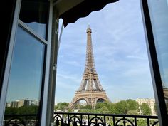 the eiffel tower is seen through an open window