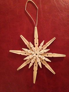 a wooden ornament hanging on a red leather surface with strings attached to it