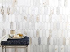 a table with a plate and cup on it in front of a marble tile wall