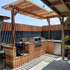 an outdoor kitchen with grill, sink and bbq