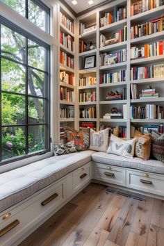 a room filled with lots of books on top of a book shelf next to a window