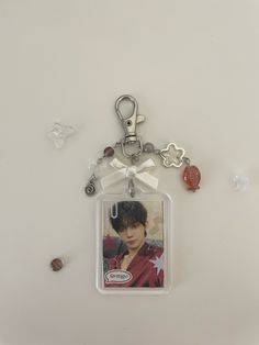 a keychain with an image of a boy on it and charms attached to it