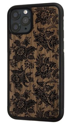 an iphone case with wood and black floral designs on the back, in front of a white background