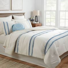 a bed with white and blue comforters in a bedroom