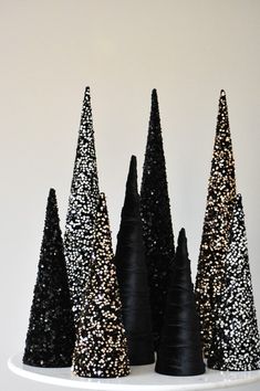 black and gold glittered cones are sitting on a white plate