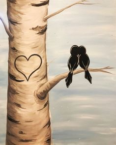 two birds sitting on a tree branch with a heart painted on it's trunk