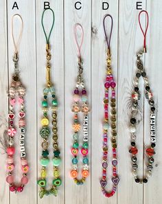 four different necklaces with name tags on them and beaded charms hanging from the strings