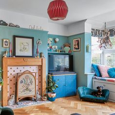 a living room filled with furniture and a flat screen tv mounted on a wall above a fire place