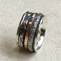 Hidden Place This spinner unisex ring is a true beauty. The wide silver band is adorned with a gold filled spinner ring and two detailed silver spinners. (R2459) © 2011-2017 Artisanimpact Inc. All rights reserved. Construction & Dimensions: Sterling silver, gold filled Approximate width: 12mm (0.47 inch) please indicate your size in your order. About our jewelry Artisanlook offers an exciting collection, designed and made by artisanimpact inc, especially for occasions: wedding, engagement an Bohemian Wide Band Rings For Anniversary, Bohemian Rings With Engraved Wide Band, Bohemian Wide Band Rings Engraved, Bohemian Wide Band Engraved Rings, Bohemian Wide Band Promise Ring, Bohemian Style Promise Ring With Wide Band, Heirloom Silver Ring With Thick Band, Bohemian Style Wide Band Promise Ring, Stacking Rings Gold