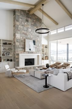 a living room filled with furniture and a fire place in front of a stone wall