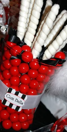 a red and white vase filled with lots of candy