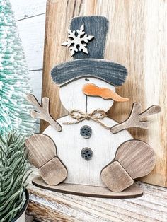 a wooden snowman sitting on top of a shelf