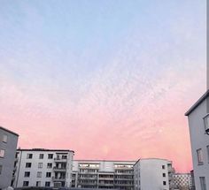 the sky is pink and blue over some buildings