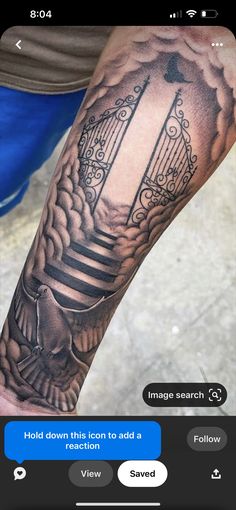 a man's arm with a bird and gate tattoo on it