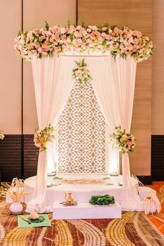 a wedding cake with pink flowers on top and white draping over the front