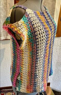 a multicolored crocheted shawl on a mannequin