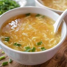 two white bowls filled with soup on top of a wooden table next to broccoli