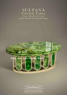 the table is made out of glass and has green leaves on it, as well as metal