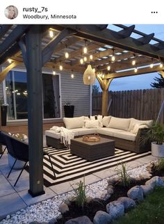 an outdoor living area with patio furniture and string lights on the pergolated roof