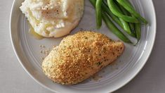 a white plate topped with meat, mashed potatoes and green beans