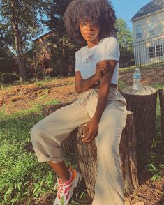 a woman sitting on top of a tree stump