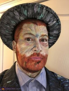 a man in a suit and hat with his face painted to look like an artist