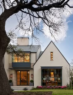 a white house with large windows on the front and side of it's roof