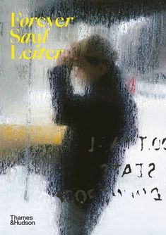 a woman standing under an umbrella in the rain with her hand on her head,