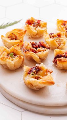 small pastries are arranged on a white platter with rosemary sprigs in the background