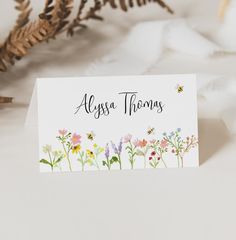 there is a card with flowers on it and the name alessa thomas written in black ink