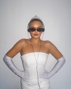 a woman in white dress with headphones and gloves on her shoulders, wearing sunglasses