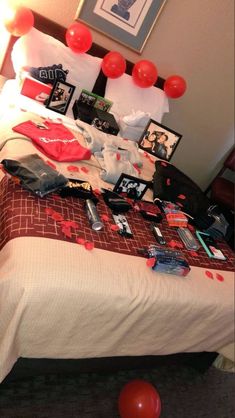 a bed with red balloons and pictures on it