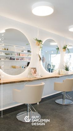 the interior of a beauty salon with stools and mirrors on the wall above it