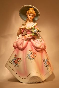 a ceramic figurine with a hat on top of it's head and dress