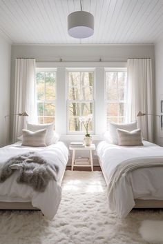 two beds in a bedroom with white walls and carpet