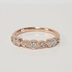 a rose gold ring with three diamonds on the side and two rows of stones in the middle