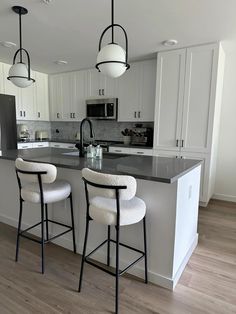 three stools sit at the center of a kitchen island