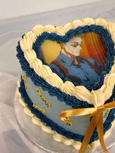 a heart shaped cake with an image of a soldier on the side and gold ribbon around it