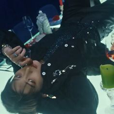 a woman laying on the floor next to a table filled with drinks and other items