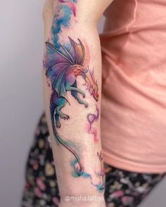 a woman's arm with a dragon tattoo on the left side of her arm