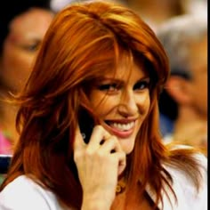 a woman talking on a cell phone while sitting in front of a group of people