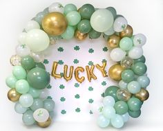 a bunch of balloons that are in the shape of shamrocks and lucky written on them