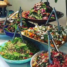 a table topped with lots of different types of salads