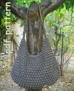 a crocheted purse hanging from a tree branch