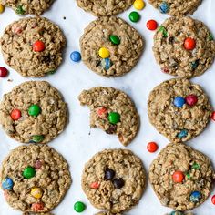 cookies with m & m's and candy on top are lined up in rows