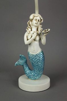 a figurine of a mermaid holding a plate